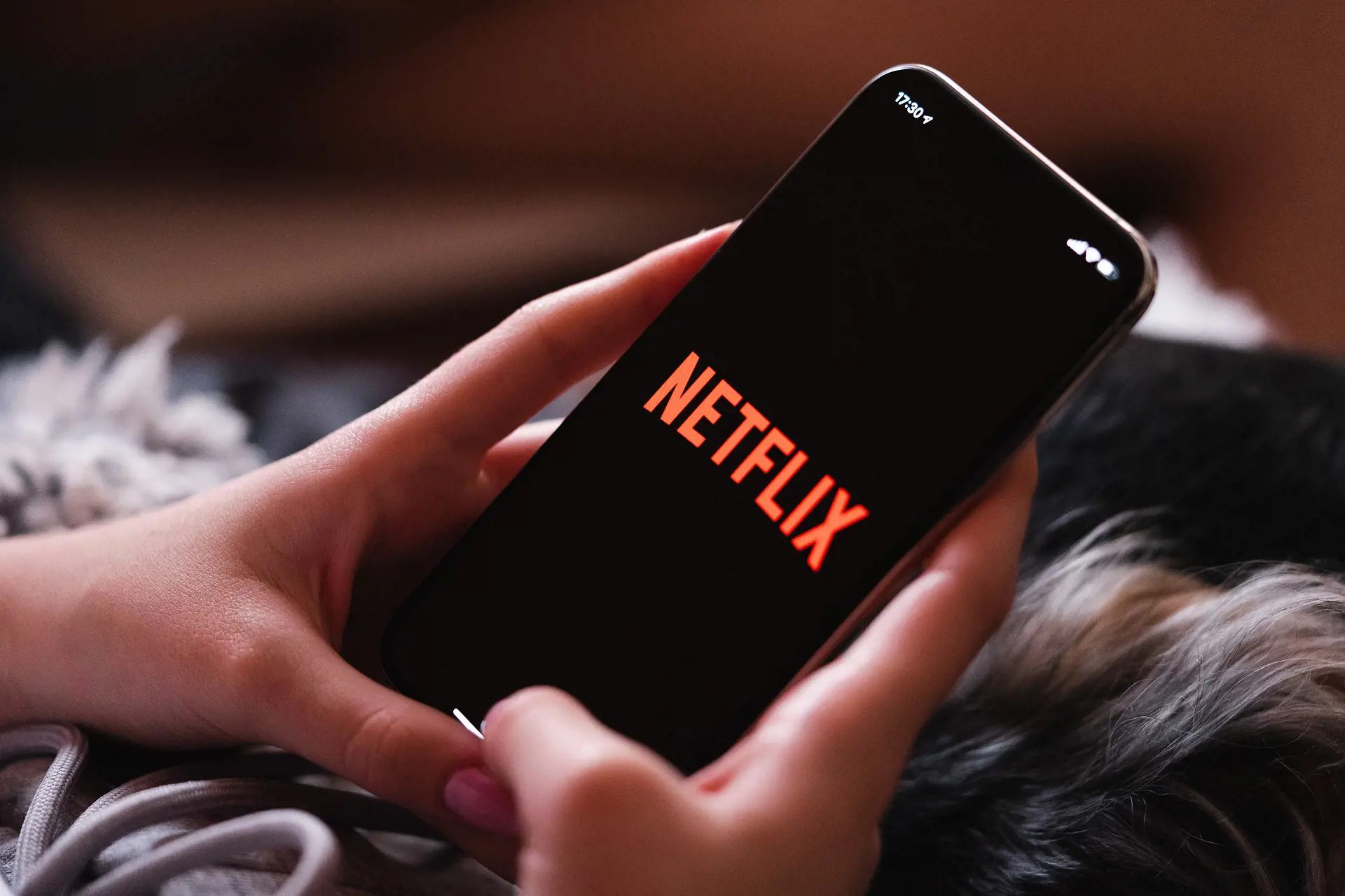 The Value Of Measuring Data Netflix a person using netflix on their mobile