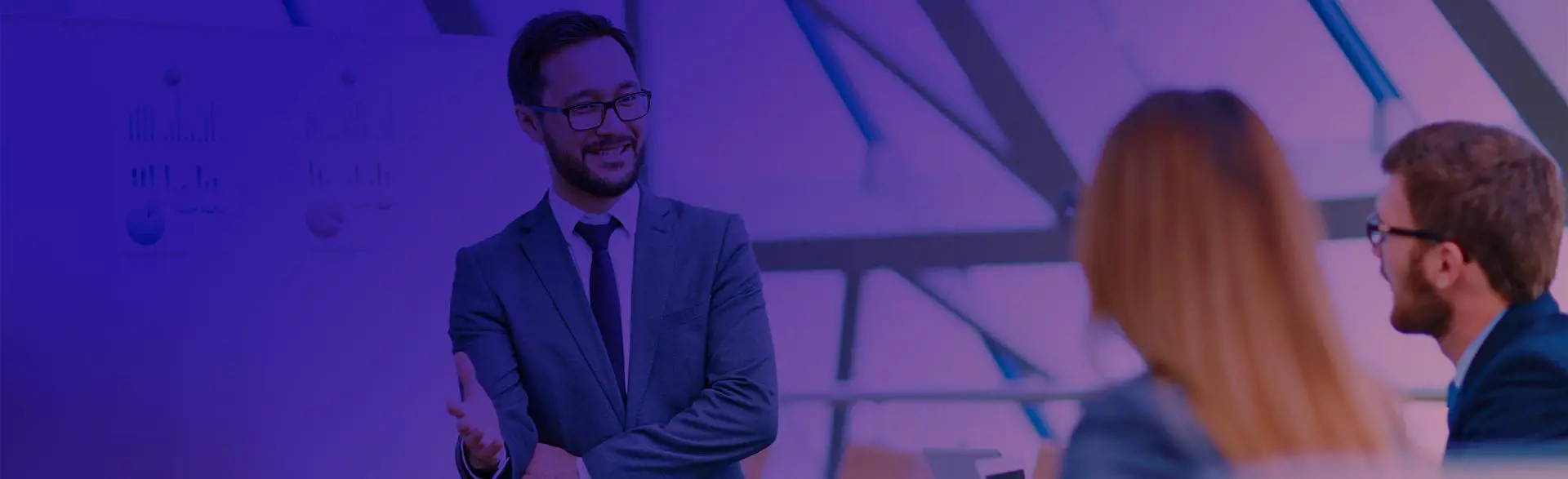 Excedo Learning Solutions Header a man smiling with two people looking at him