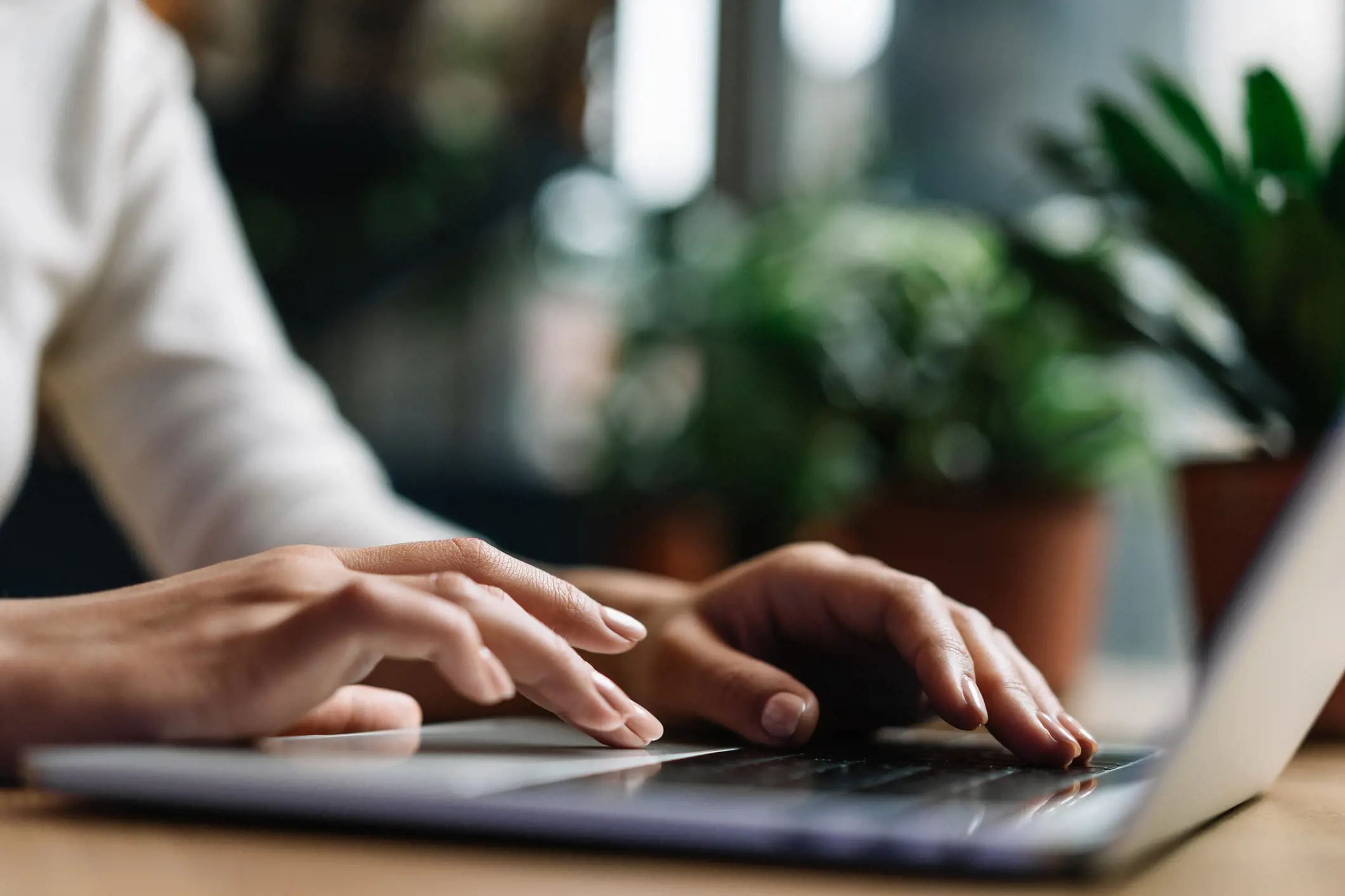 close up of hands typing on a laptop keyboard 