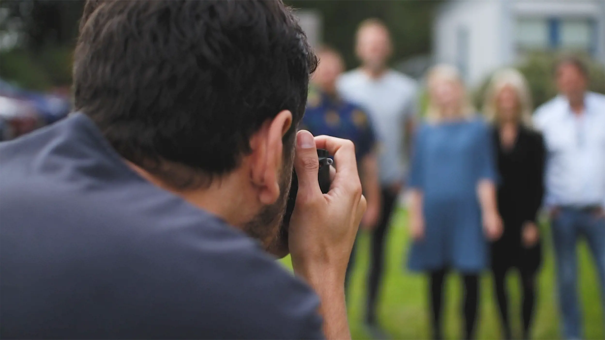 En fotograf tager et billede af en gruppe på flere personer.