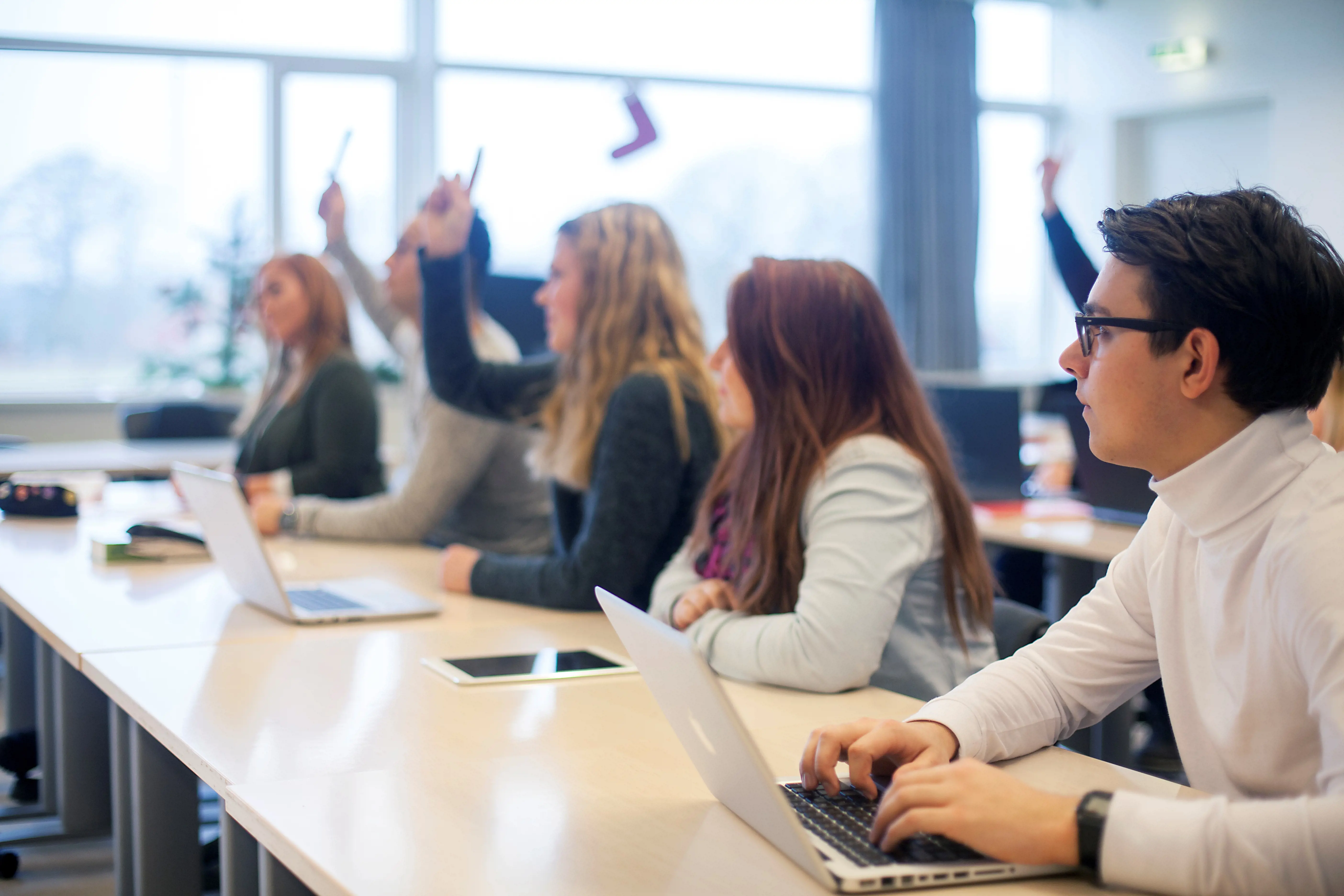 group of students with hands up