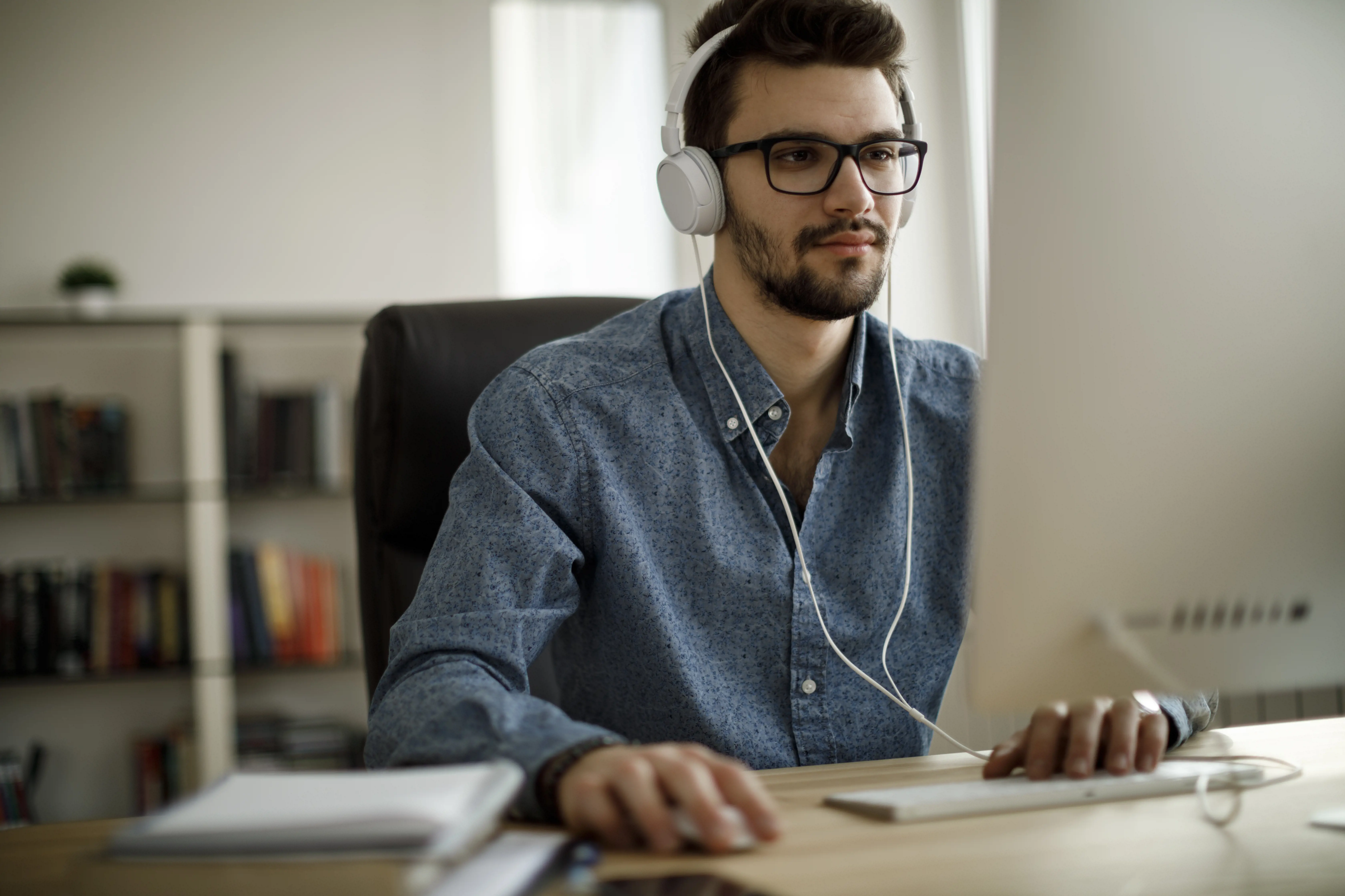 man with headphones working on computer